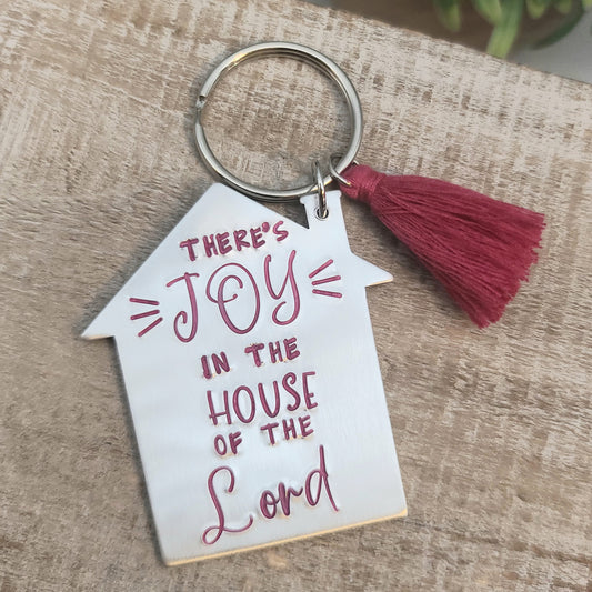 Shape of a house, hand stamped "Joy in the House of the Lord", coordinating tassel: aluminum keychain.