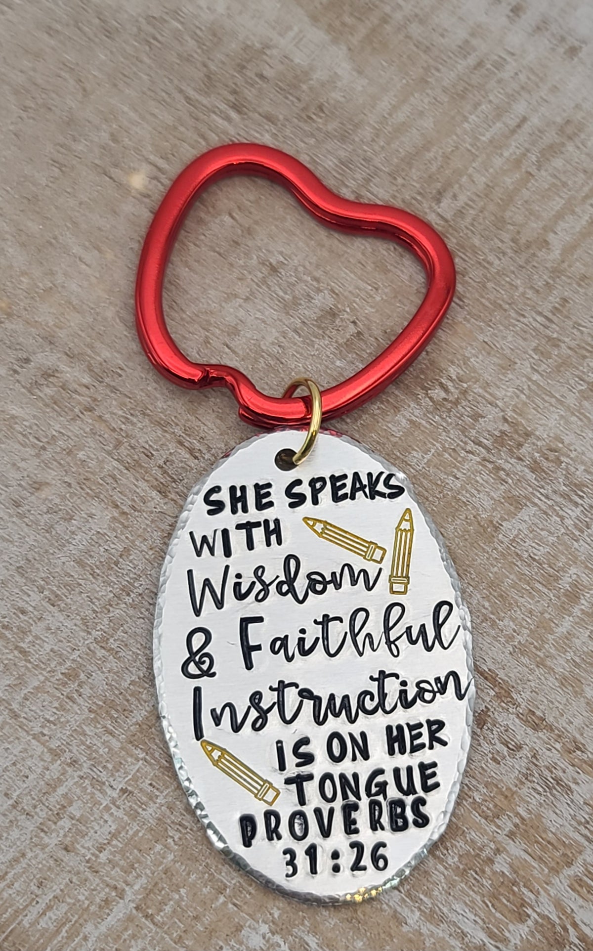Crafted from aluminum, this keychain features a hand stamped Proverbs 31:26 verse, "She speaks with wisdom". Red apple keyring adds a perfect finish for teachers.