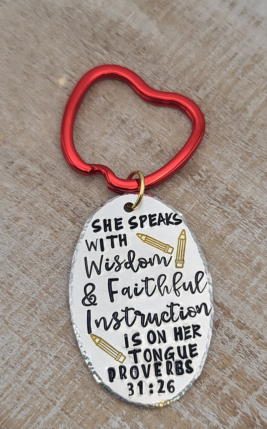Crafted from aluminum, this keychain features a hand stamped Proverbs 31:26 verse, "She speaks with wisdom". Red apple keyring adds a perfect finish for teachers.