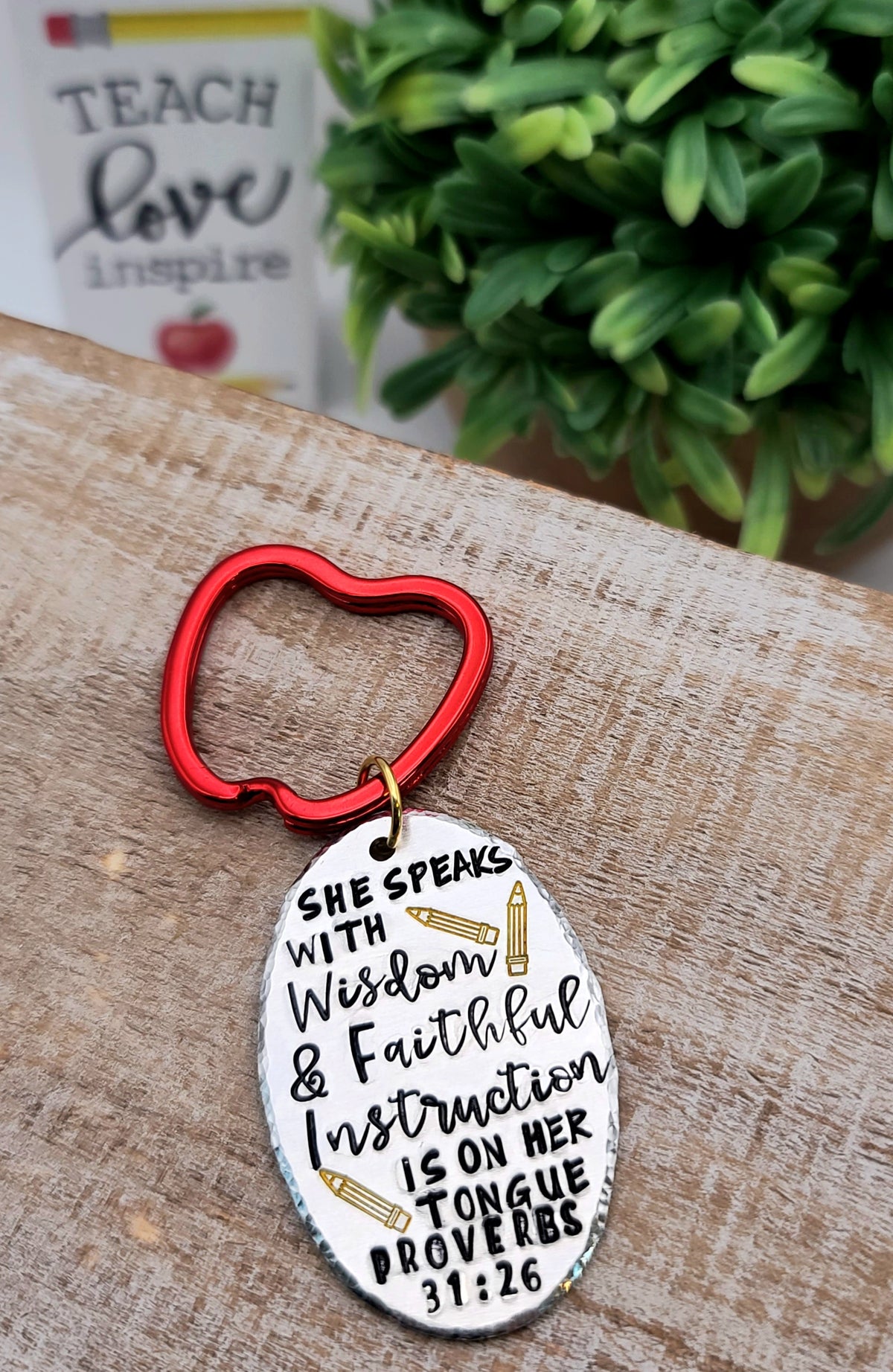 Crafted from aluminum, this keychain features a hand stamped Proverbs 31:26 verse, "She speaks with wisdom". Red apple keyring adds a perfect finish for teachers.